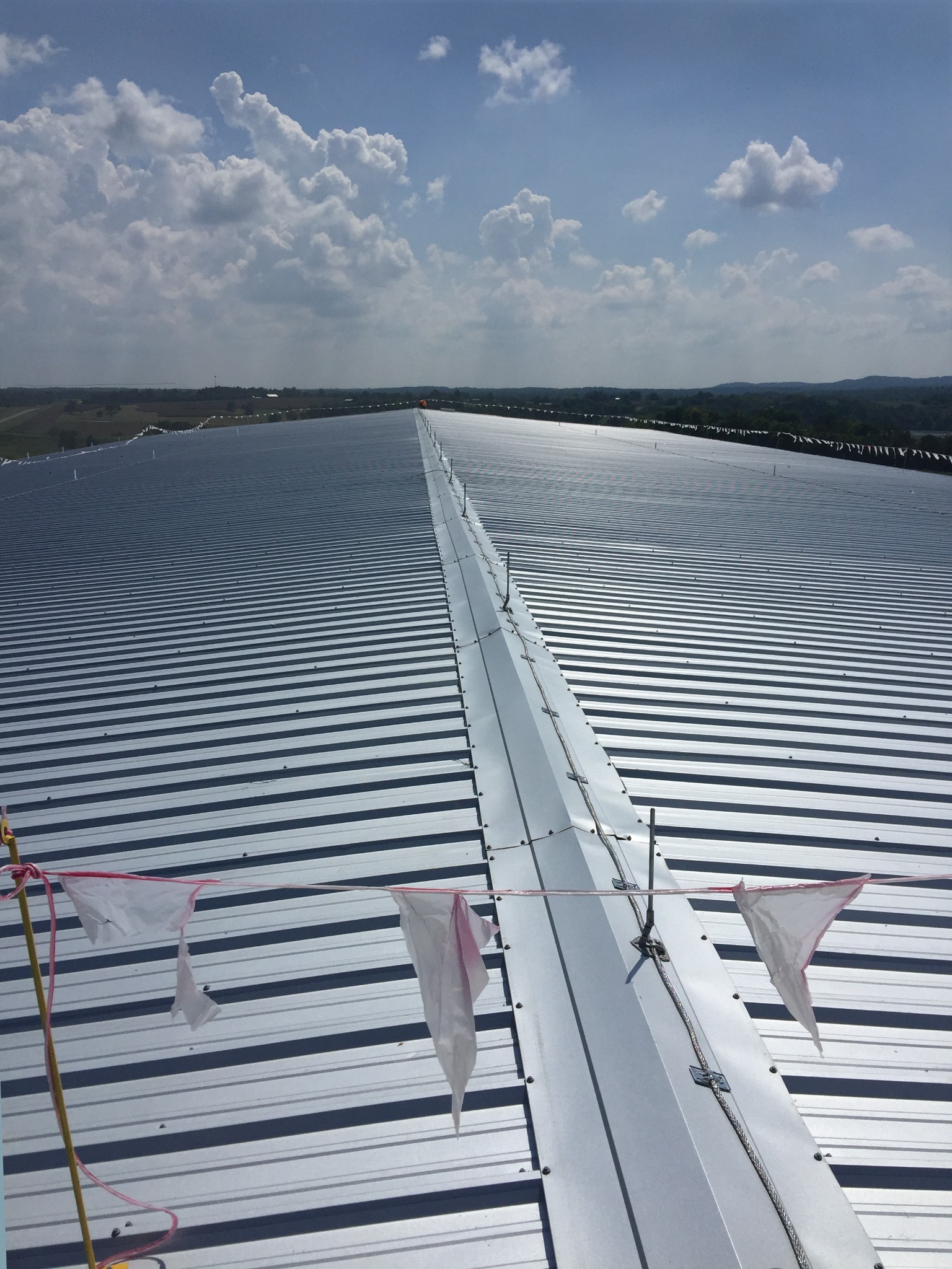 Large standing seam metal building reference showing ridge conductor runs and air terminal placement.