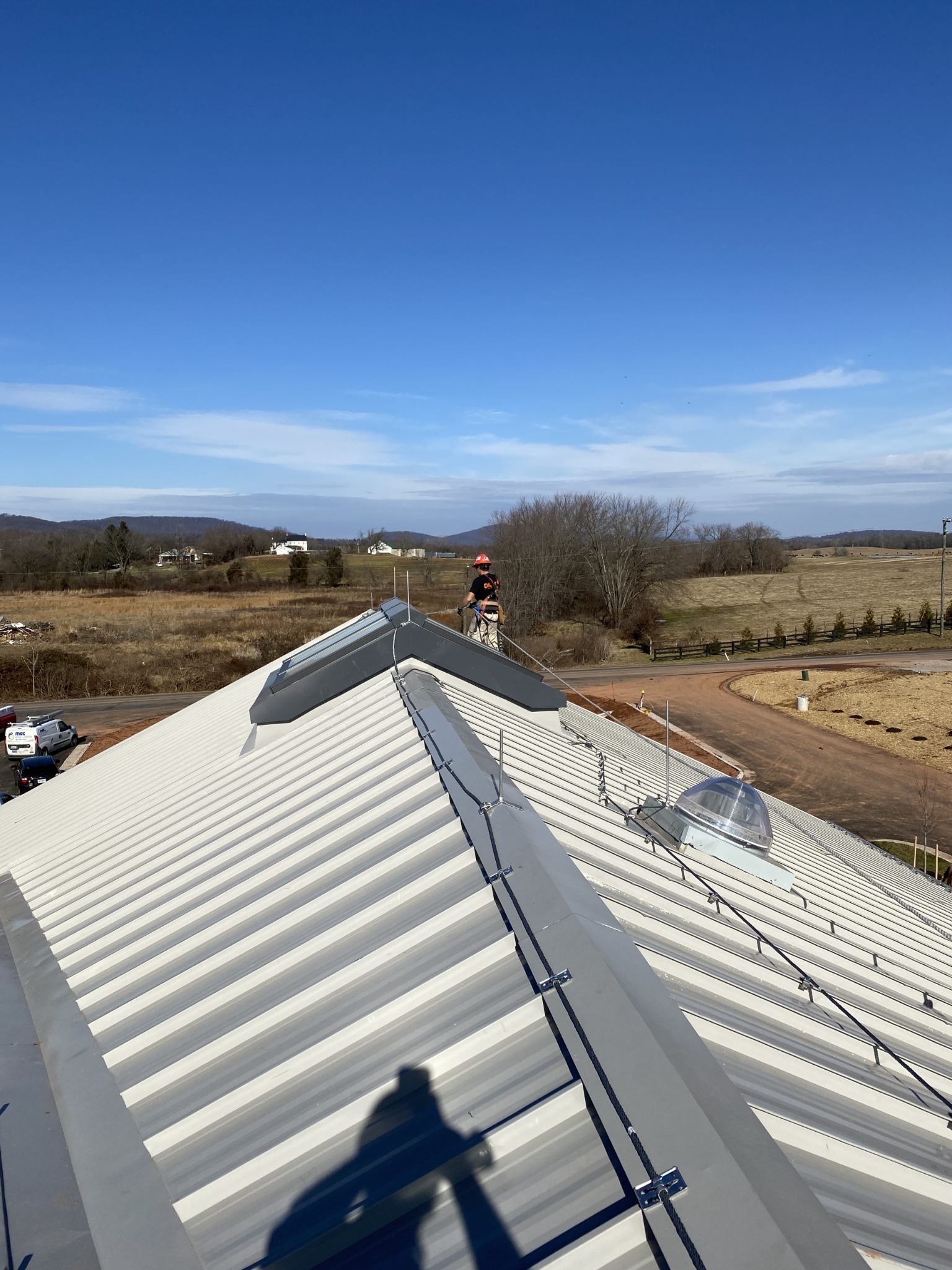 Standing seam metal roof lightning protection reference with ridge-mounted conductors and air terminals.